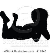 Vector Illustration of a Black Silhouetted Boy Resting on His Stomach by AtStockIllustration
