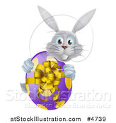 Vector Illustration of a Gray Bunny Holding an Easter Egg by AtStockIllustration