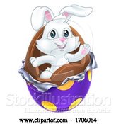 Vector Illustration of Cartoon Easter Bunny Rabbit Breaking Chocolate Egg Cartoon by AtStockIllustration