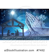 Vector Illustration of Engraved Praying Hands over a Silhouetted Christmas Nativity Scene at the Manger with the Star of Bethlehem and City in Blue Tones by AtStockIllustration
